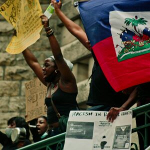 Protesters in Montreal holding Haitian flag and signs advocating for racial justice.